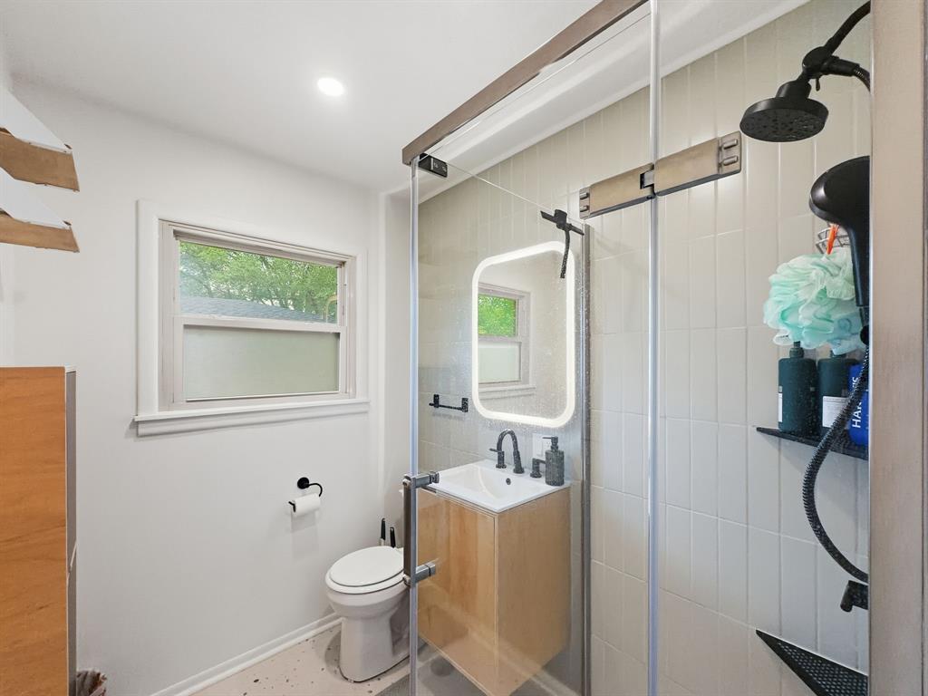 2137 Lenamon Street Waco, TX 76710 - Photo 12 of 29 Contemporary bathroom featuring a glass-enclosed shower with matte black fixtures and a tiled surround