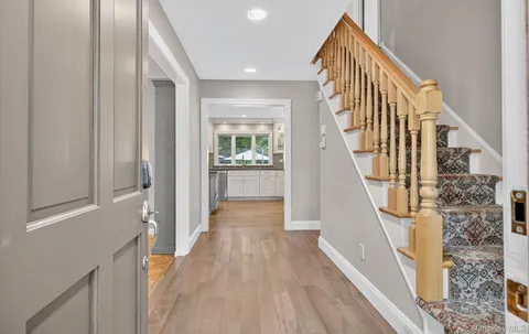 a view of a hallway with wooden floor and staircase