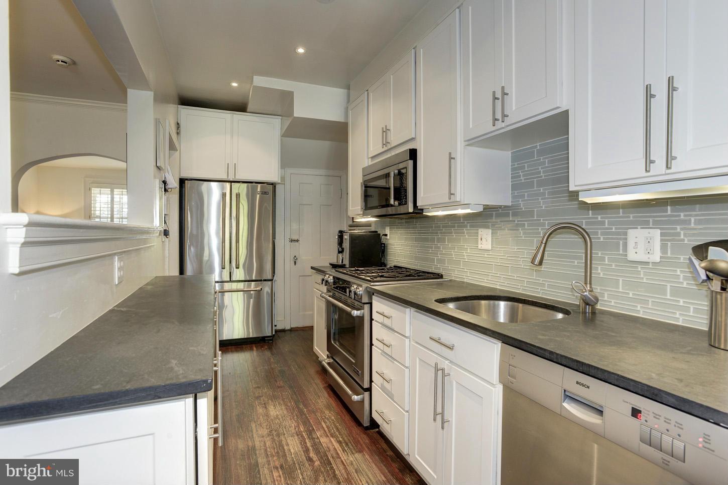 3813 T Street Northwest Washington, DC 20007 - Photo 7 of 24 a kitchen with stainless steel appliances granite countertop a sink stove refrigerator and cabinets