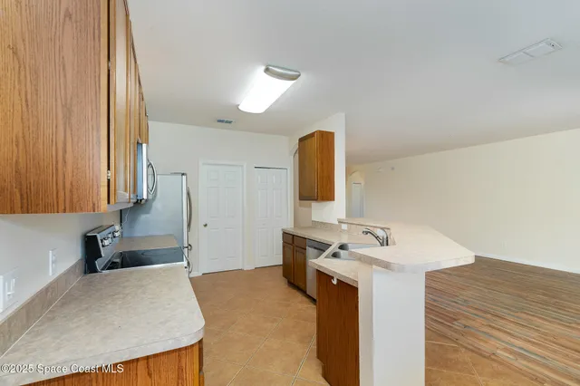 a kitchen with stainless steel appliances granite countertop a sink a stove and a refrigerator