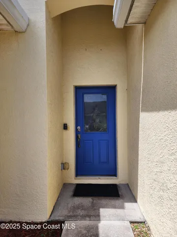 a view of a hallway with wooden floor and a mirror