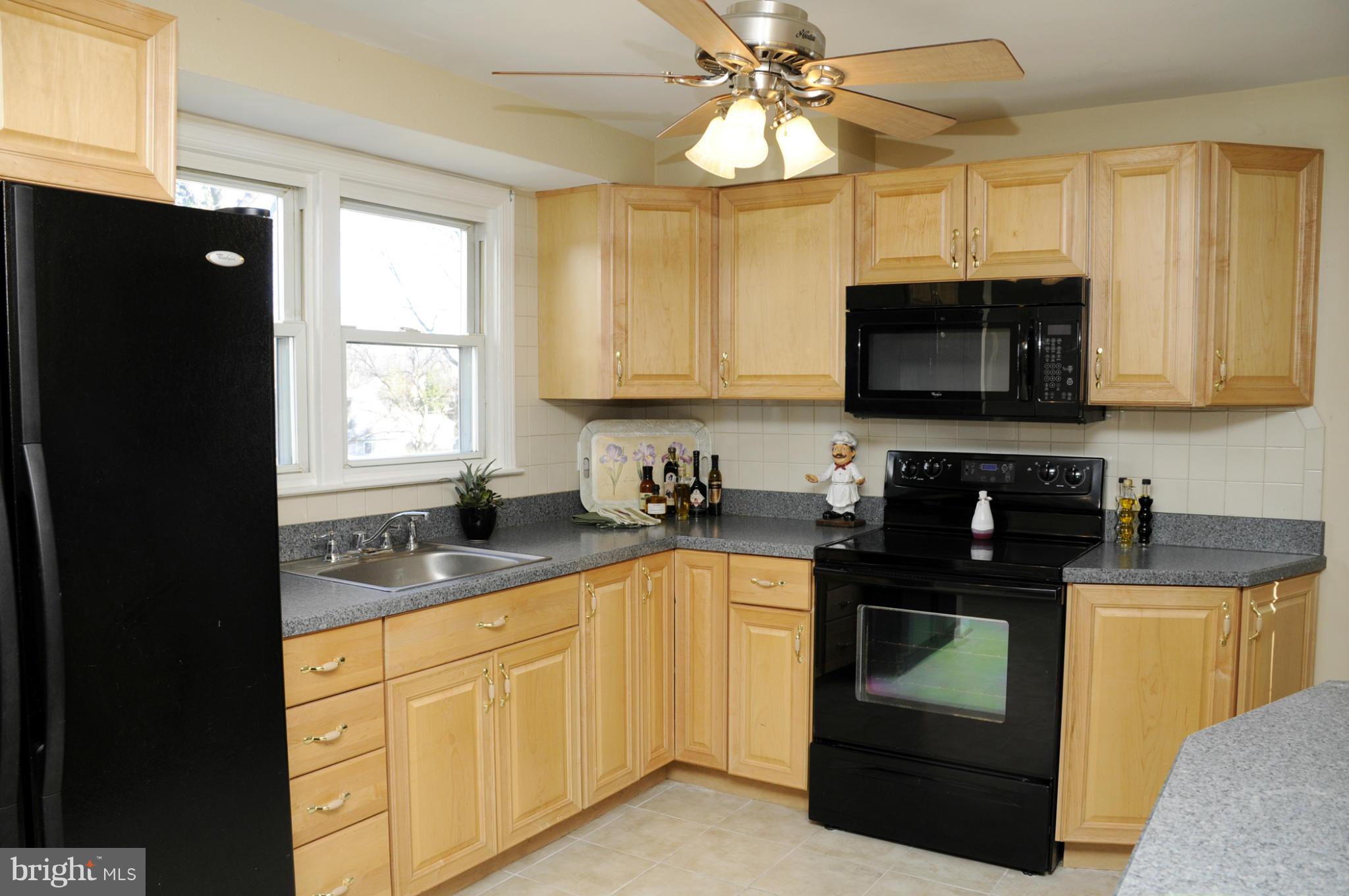 606 Cleveland Road Linthicum Heights, MD 21090 - Photo 4 of 24 a kitchen with stainless steel appliances granite countertop a stove a sink and a microwave