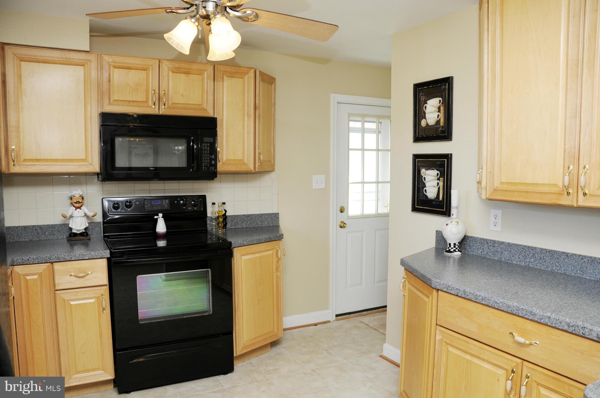 606 Cleveland Road Linthicum Heights, MD 21090 - Photo 5 of 24 a kitchen with stainless steel appliances granite countertop a stove a sink and a microwave