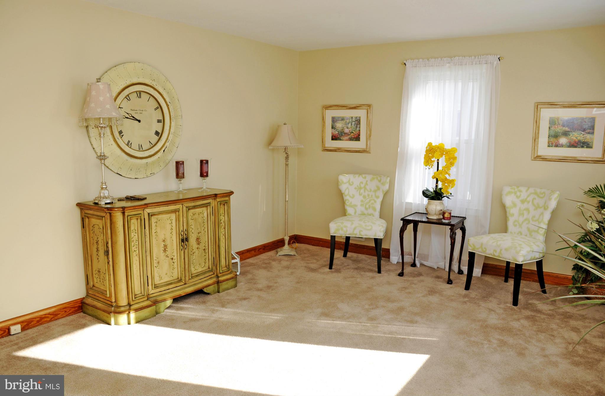 606 Cleveland Road Linthicum Heights, MD 21090 - Photo 10 of 24 a living room with furniture a clock on wall and a table