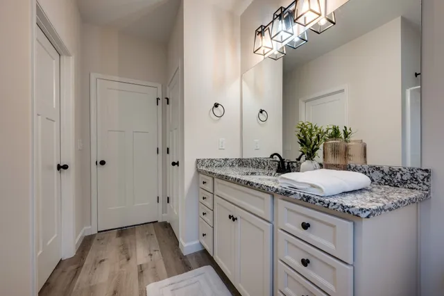 a bathroom with a granite countertop sink and a mirror