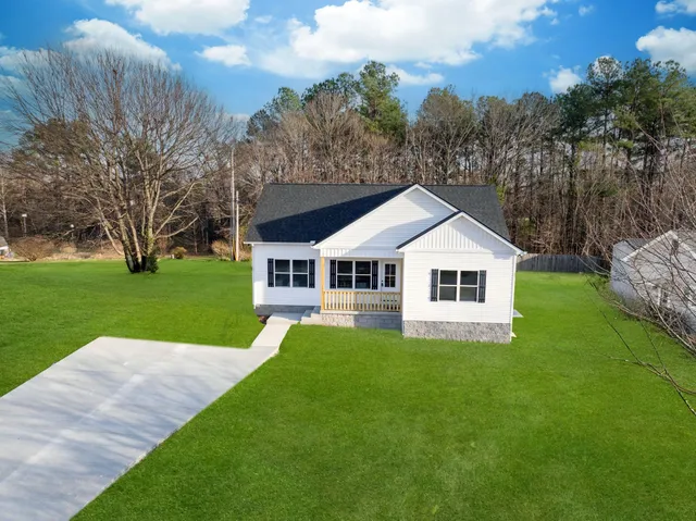 a front view of a house with yard and green space