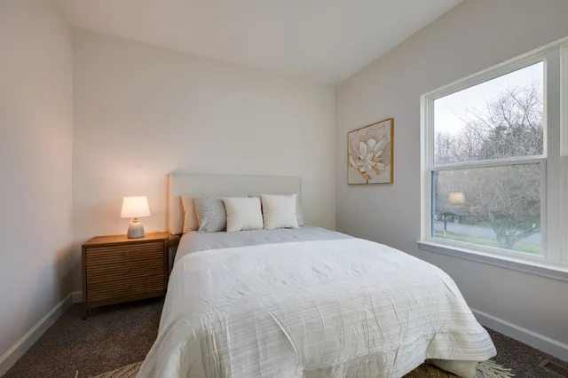 a bedroom with a bed lamp and window