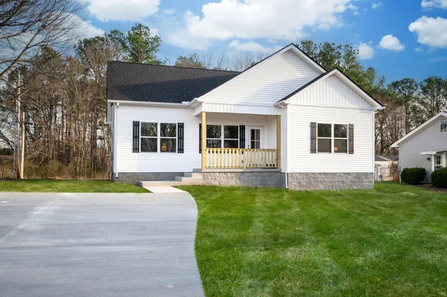 a view of a house with a yard and sitting area