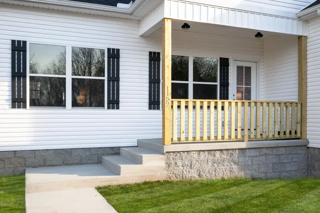 a view of a house with a small yard and wooden fence
