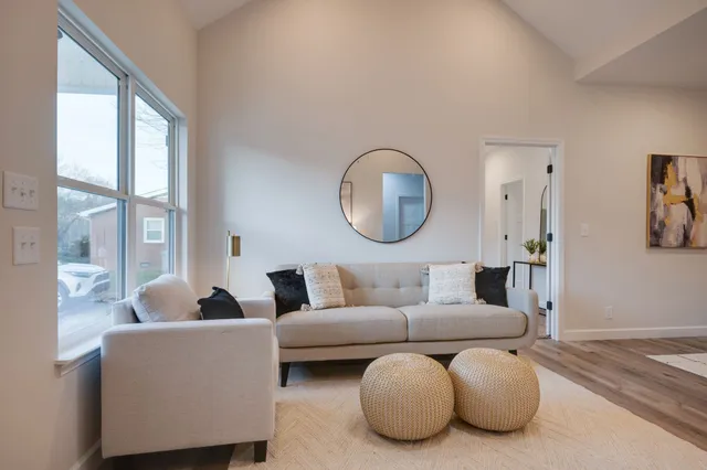 a living room with furniture a large window mirror and a large mirror next to a window