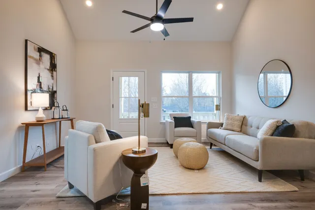 a living room with furniture a window and a potted plant