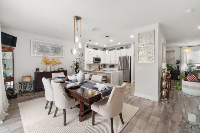 a dining room with furniture a chandelier and wooden floor