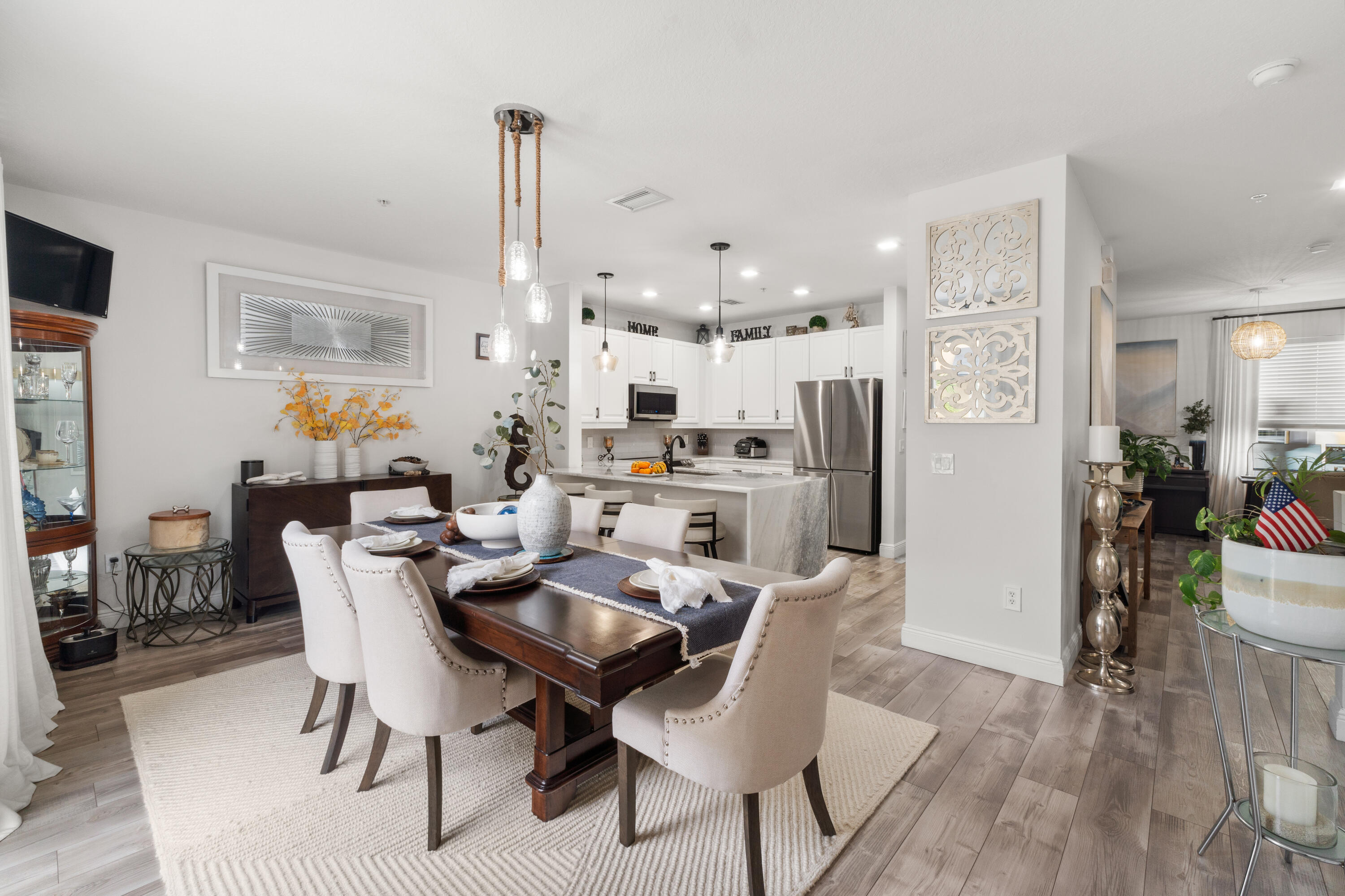 a dining room with furniture a chandelier and wooden floor
