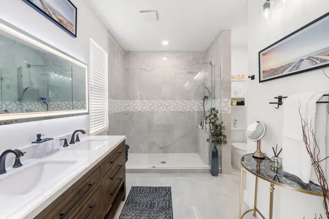 a bathroom with a double vanity sink toilet and shower