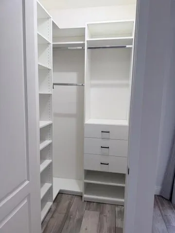 a view of walk in closet with empty racks