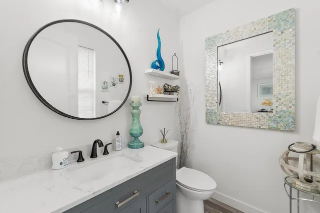 a bathroom with a sink a toilet and a mirror