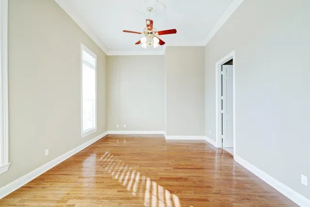 a view of a room with wooden floor and a ceiling fan