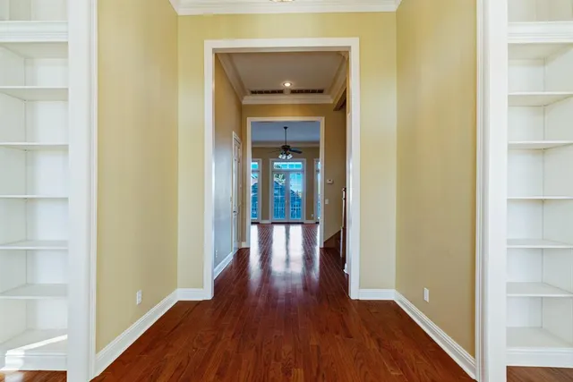 a view of a hallway with wooden floor and closet