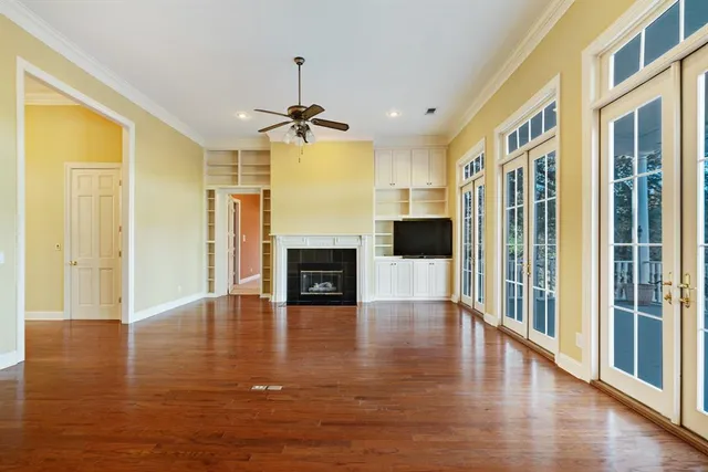 a view of a livingroom with a ceiling fan window and wooden floor