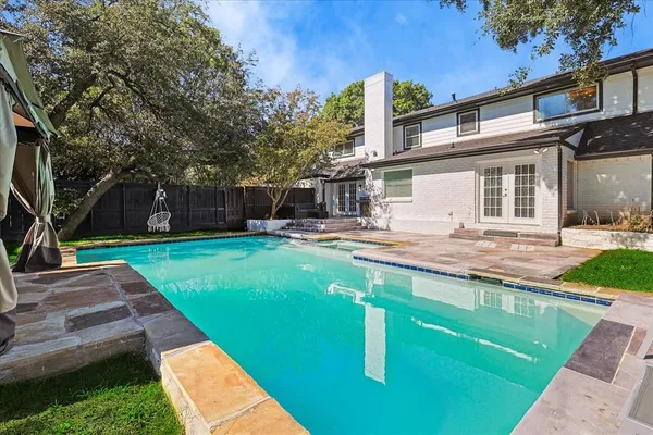 a house view with swimming pool and garden space