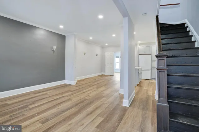 a view of hallway with stairs and wooden floor