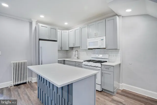 a kitchen with a sink a stove a refrigerator and white cabinets