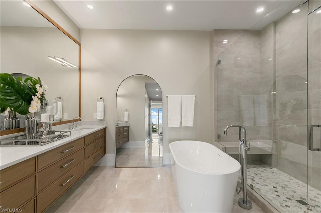 201 8th Street South, Unit 301 Naples, FL 34102 - Photo 17 of 43 a spacious bathroom with a granite countertop sink a toilet a mirror and shower