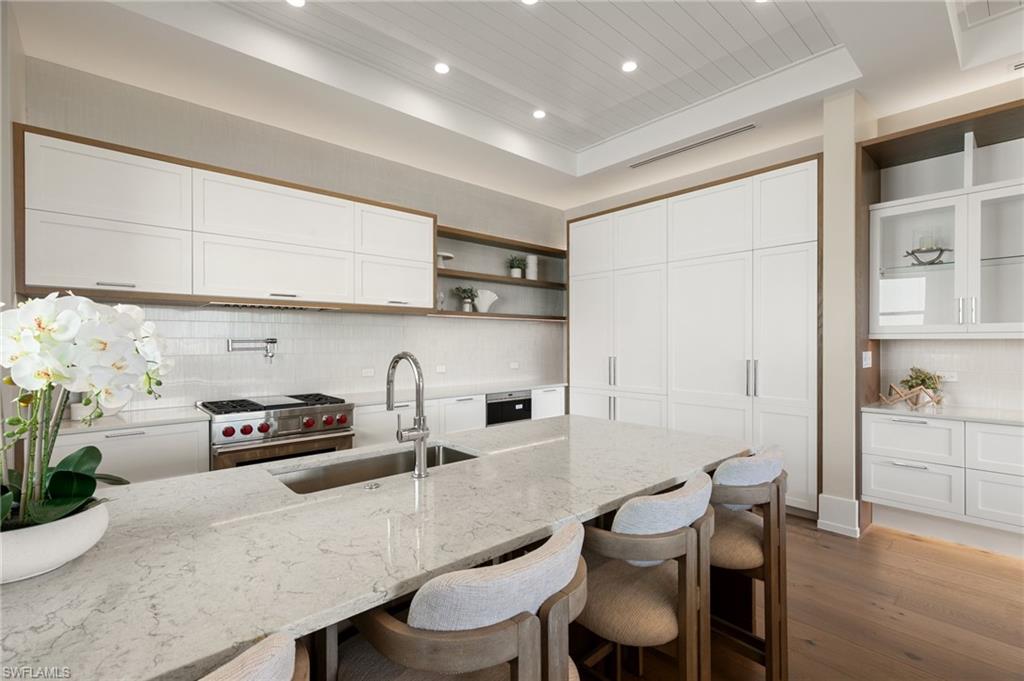 201 8th Street South, Unit 301 Naples, FL 34102 - Photo 2 of 43 a kitchen with granite countertop a table chairs stove and cabinets