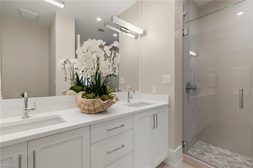 201 8th Street South, Unit 301 Naples, FL 34102 - Photo 25 of 43 a bathroom with a granite countertop sink a potted plant and a shower