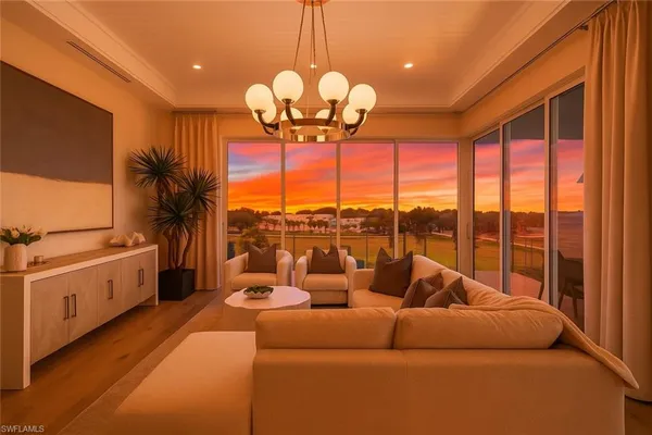 a living room with furniture a chandelier and a large window