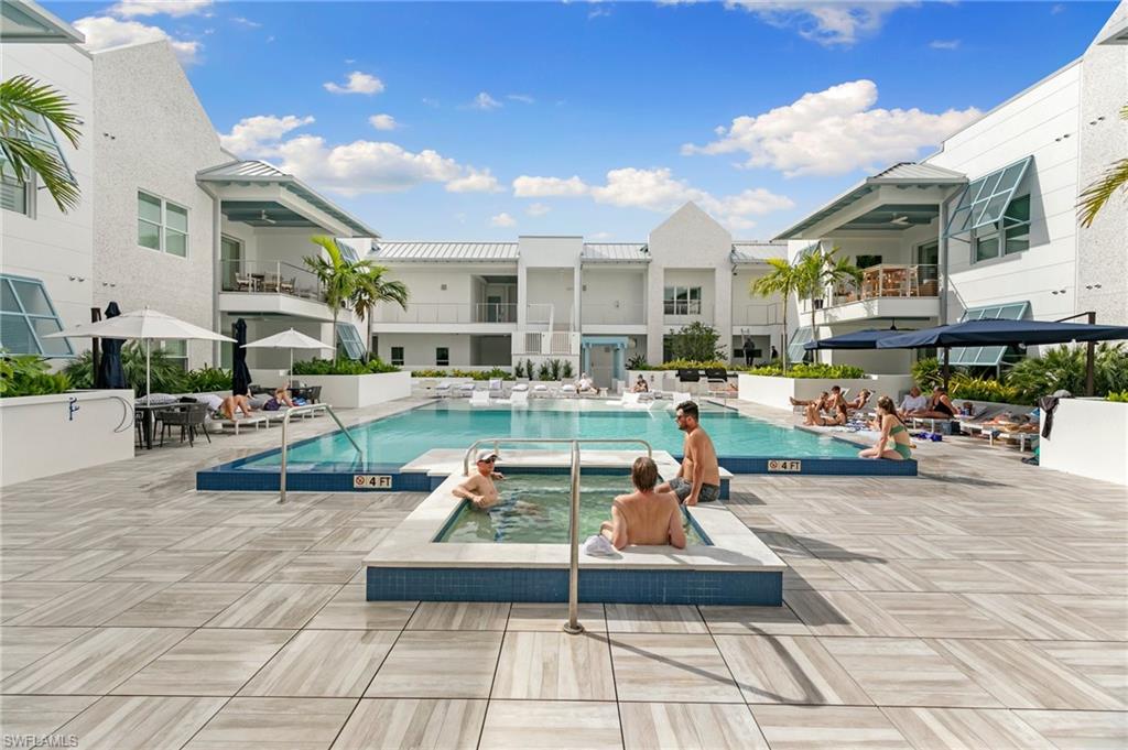 201 8th Street South, Unit 301 Naples, FL 34102 - Photo 33 of 43 a view of a patio with dining table and chairs with plants and wooden fence