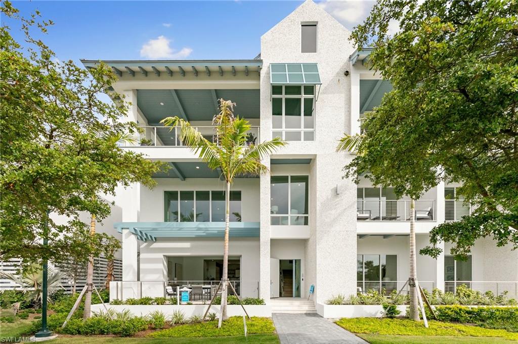 201 8th Street South, Unit 301 Naples, FL 34102 - Photo 41 of 43 a front view of a building with a garden and plants