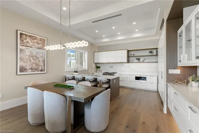 a living room with furniture a chandelier and a large window