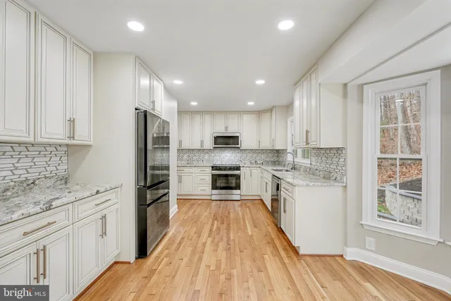 a kitchen with granite countertop a sink a stove and cabinets
