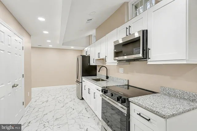 a kitchen with stainless steel appliances a refrigerator sink and cabinets