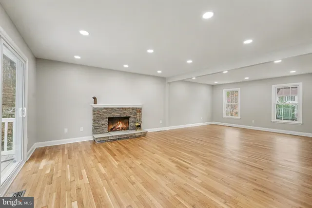 a view of an empty room with a fireplace and a window