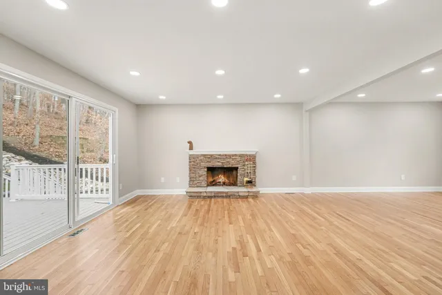a view of an empty room with a fireplace and a window