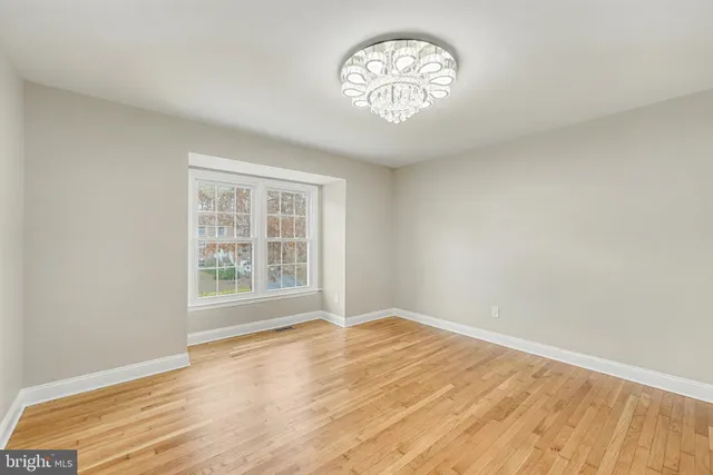 a large kitchen with cabinets wooden floor stainless steel appliances and a window