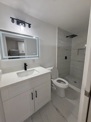 a kitchen with granite countertop white cabinets and refrigerator