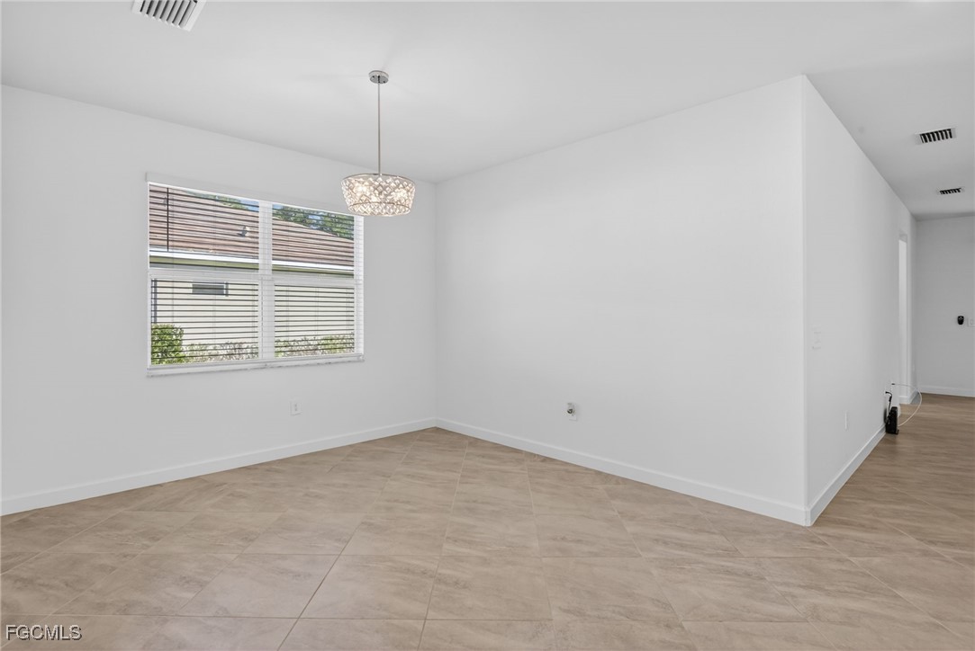 17364 Walnut Run Drive Alva, FL 33920 - Photo 12 of 50 an empty room with windows and chandelier fan