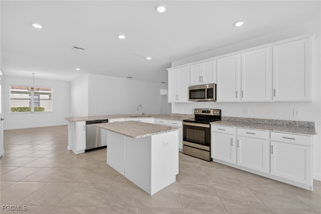17364 Walnut Run Drive Alva, FL 33920 - Photo 17 of 50 a kitchen with granite countertop white cabinets and stainless steel appliances