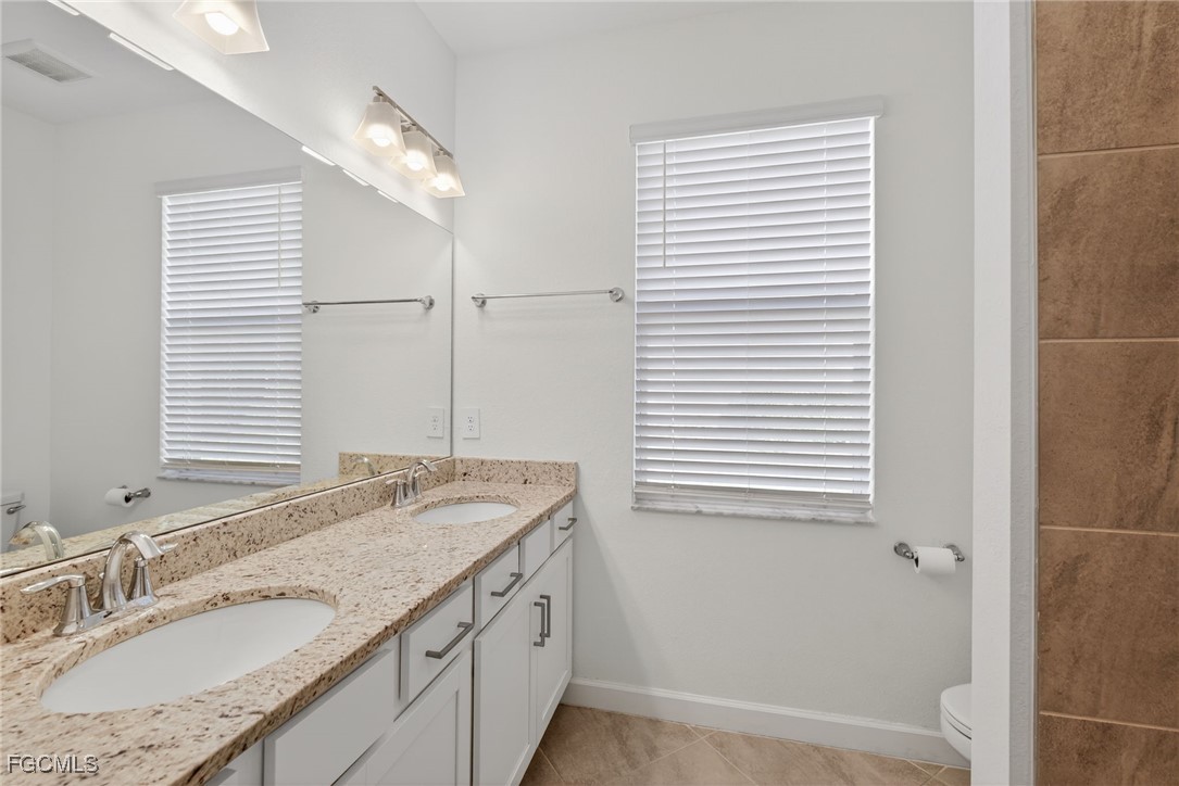 17364 Walnut Run Drive Alva, FL 33920 - Photo 30 of 50 a bathroom with a granite countertop sink and a mirror