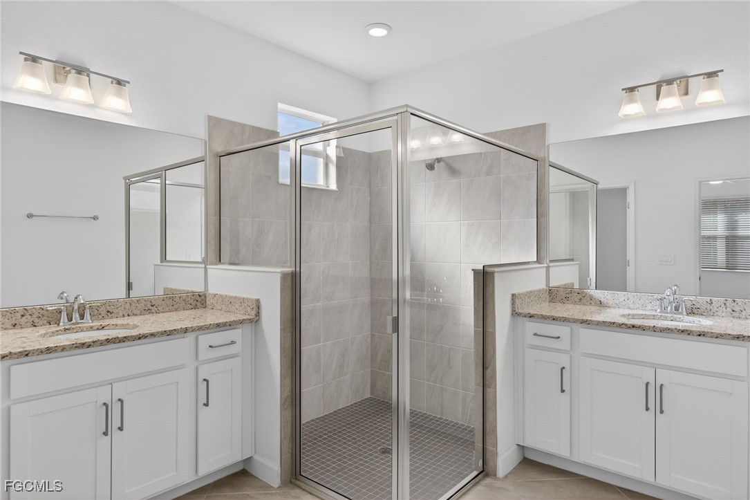 17364 Walnut Run Drive Alva, FL 33920 - Photo 40 of 50 a bathroom with a granite countertop sink a mirror a shower and vanity
