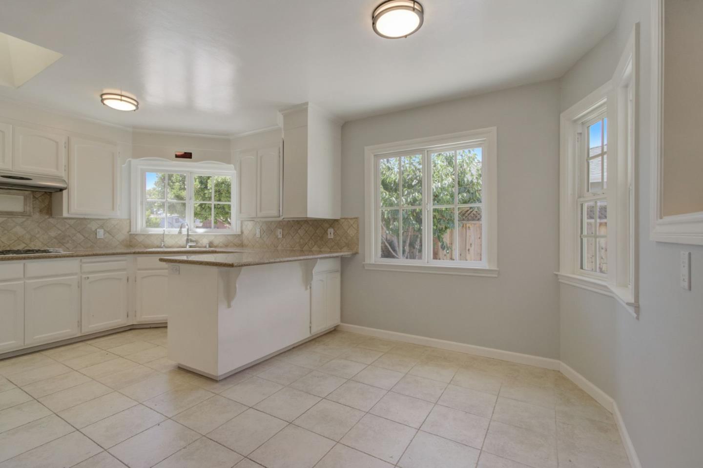 613 North Central Avenue Campbell, CA 95008 - Photo 13 of 66 a kitchen with granite countertop white cabinets and window