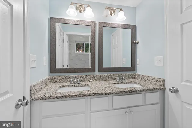a bathroom with a granite countertop sink and a mirror