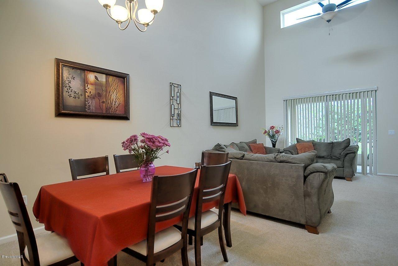 620 Bismarck Way Indialantic, FL 32903 - Photo 2 of 14 a living room with furniture a chandelier and a dining room