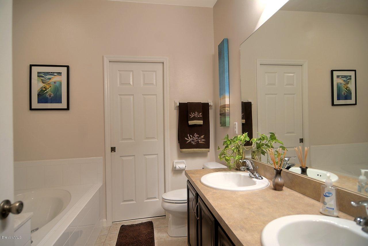 620 Bismarck Way Indialantic, FL 32903 - Photo 11 of 14 a bathroom with a granite countertop sink a toilet a shower and a bathtub