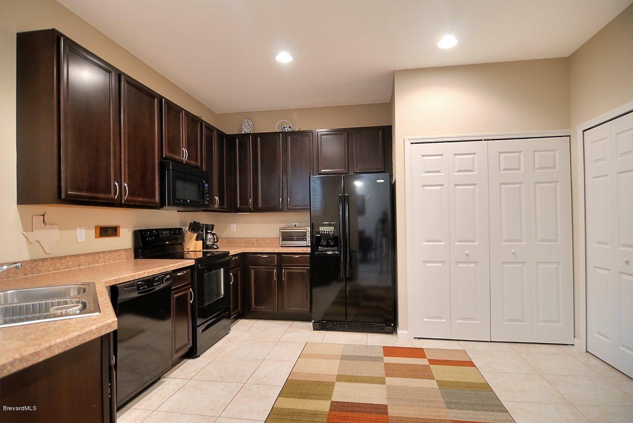 620 Bismarck Way Indialantic, FL 32903 - Photo 3 of 14 a kitchen with stainless steel appliances granite countertop a refrigerator and a stove top oven