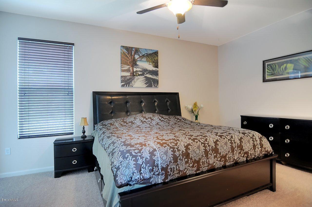 620 Bismarck Way Indialantic, FL 32903 - Photo 10 of 14 a bedroom with a bed and a lamp on dresser