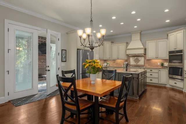 a view of a dining room with furniture a chandelier and wooden floor